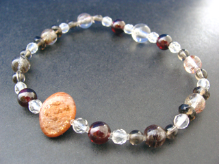 フェルドスパー【サンストーン】（オレンジ・アベンチュリン効果）人間的な成長をもたらす　ルチルクォーツ（クリア・ブロンズゴールド針入り・６ｍｍ）ビジネスの成功・長寿・健康　ガーネット（レッド・６ｍｍ）生命力・エネルギー・活力・努力・抵抗力・色気・根性・気力・独立　クォーツ（クリア・８ｍｍ）健康・能力・明晰・完璧・宇宙的意識・感受性・沈着冷静・豊かな感受性　スモーキークォーツ（ブラウン・ボタンカット）リラックス効果・豊かな感受性