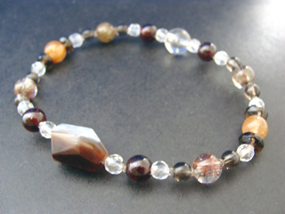 カルセドニー【ファイアーアゲート】（ブラウン・ファイアイリデッセンス効果）長寿・富・健康・家内安全　ルチルクォーツ（クリア・ブロンズゴールド針入り・６ｍｍ）ビジネスの成功・長寿・健康　ガーネット（レッド・６ｍｍ）生命力・エネルギー・活力・努力・抵抗力・色気・根性・気力・独立　クォーツ（クリア・８ｍｍ）健康・能力・明晰・完璧・宇宙的意識・感受性・沈着冷静・豊かな感受性　スモーキークォーツ（ブラウン・ボタンカット）リラックス効果・豊かな感受性