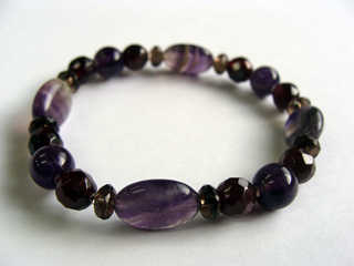 ブレスレットです。（シリコンゴム（２重・結び技法）使用・内周15.5ｃｍ）　フローライト（パープル・平型オーバル）ひらめき・集中力・直感・愛・学習・理解力・独立　クォーツ【アメジスト】（パープル）決断力・愛情・集中力・調和・第六感・献身・冷静・覚醒・精神力・豊かな感受性　ガーネット（ワイン・カット）生命力・エネルギー・活力・努力・抵抗力・色気・根性・気力・独立　スモーキークォーツ（ブラウン・ボタンカット）リラックス効果・豊かな感受性